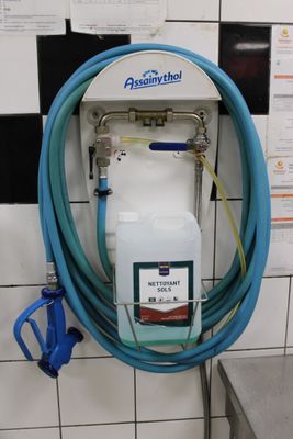 un tuyau bleu fixé au mur dans des toilettes publiques