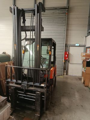 a forklift in a warehouse filled with boxes and boxes