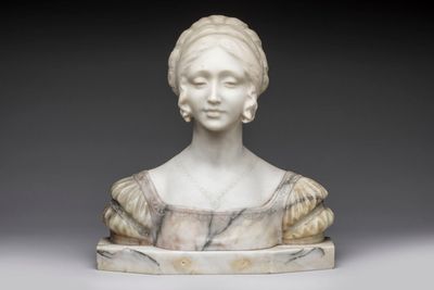 a white marble bust of a woman with a bunt on her head