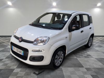 la petite voiture blanche est garée sur un carrelage à carreaux