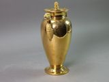 a gold vase that is sitting on a table
