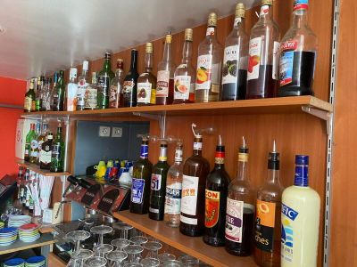many bottles and glasses on the shelves in the bar