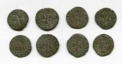 six pièces de monnaie romaines sont alignées sur une surface blanche