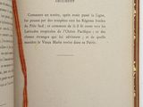 an open book with a red ribbon on the front of it