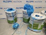 several rolls of blue and green yarn sitting on top of a table