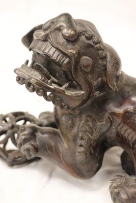 a bronze statue of a dog with a ball in it ' s mouth