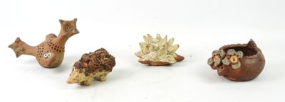 four figurines of animals that are on a white surface