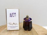 an alien perfume bottle sitting on top of a wooden table next to a box