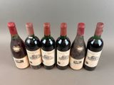six bottles of wine are lined up in a row on a table