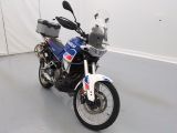 une moto bleue et blanche garée dans une pièce blanche