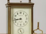 une petite horloge et une clé posées sur une table