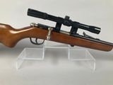 a close up of a rifle with a scope on a stand