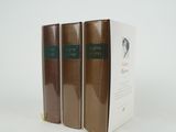 three books sitting on top of a white table next to each other