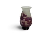 a small vase that has a purple and white design on it
