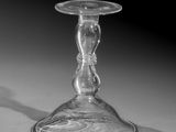 black and white photograph of a glass candle holder on a table
