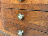 a wooden chest of drawers with glass knobs on it