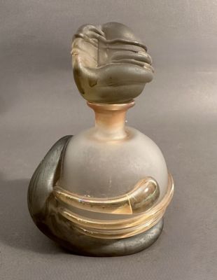 une bouteille en verre surmontée d'un oiseau