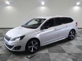la voiture blanche est garée sur un sol en damier dans le garage