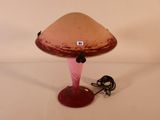 une lampe posée sur une table, à laquelle est relié un cordon