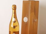 une bouteille de champagne posée sur une table à côté d'un coffret