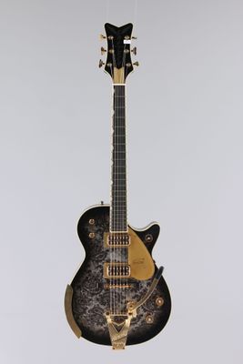 une guitare électrique noire et dorée suspendue au plafond