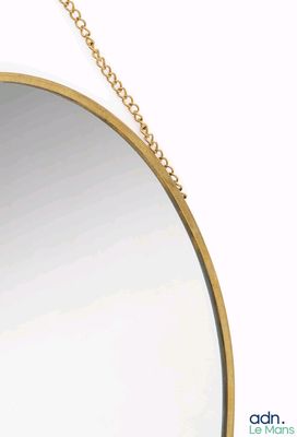 un miroir accroché à une chaîne au mur