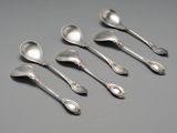six cuillères en argent ornées de motifs élaborés sur un fond gris