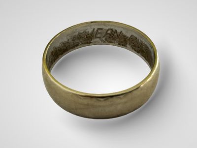 gros plan d'une bague en or sur une surface blanche