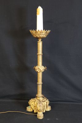 an antique brass candle holder with a white candle on top of it