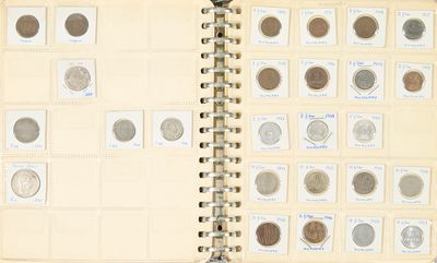 un livre ouvert sur lequel sont posées plusieurs pièces de monnaie différentes