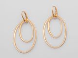 une paire de boucles d'oreilles en or sur fond blanc