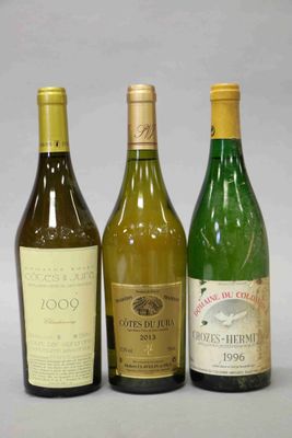 trois bouteilles de vin sont alignées sur une table