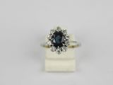 a white gold ring with a blue sapphire and diamonds