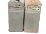 two trash cans sitting next to each other on a white surface