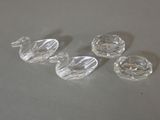trois canards en verre transparent posés les uns à côté des autres sur une table