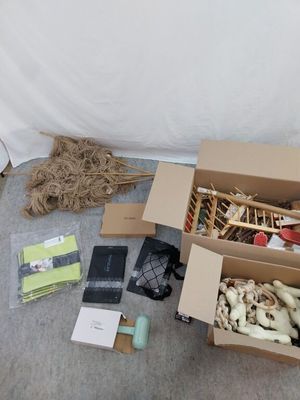 Des cartons contenant des objets divers sont posés par terre près d'un mur.
