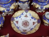 de nombreux objets en porcelaine bleue et blanche posés sur une table rouge