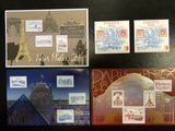 Plusieurs timbres et cartes postales différents sont exposés sur un fond noir