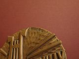 a sculpture of a clock on a table with a red wall in the background