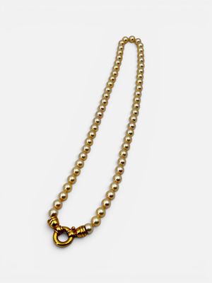 a close up of a pearl necklace with a gold clasp on a white background