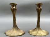 pair of antique brass candlesticks on a grey background