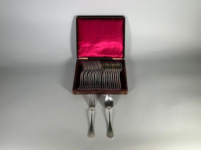 des couverts dans un étui rouge posé sur une surface blanche