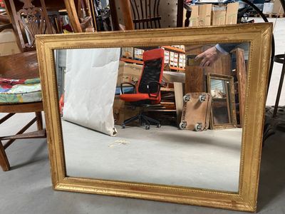 a mirror that is sitting on the floor next to a chair