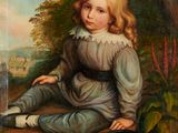portrait of a young girl seated on a rock by a river