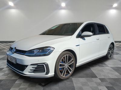 Une Volkswagen Golf blanche est garée sur un sol à damier.