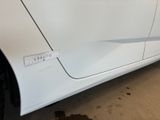 a close up of a white car with a sticker on it