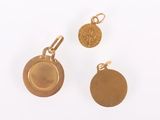 two gold coins and a coin charm on a white surface