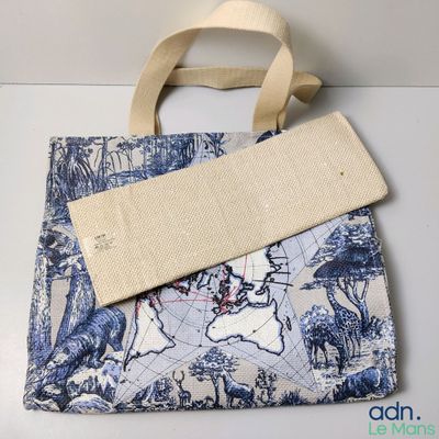une photo d'un sac fourre-tout bleu et blanc orné d'une carte du monde
