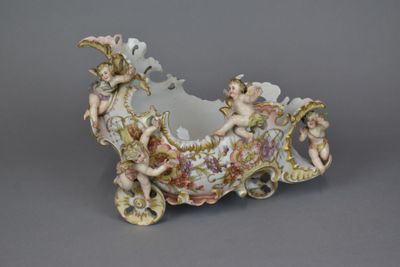 JARDINIERE en porcelaine en forme de carrosse à décor en rel…