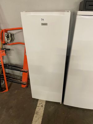 two white refrigerators in the garage next to each other